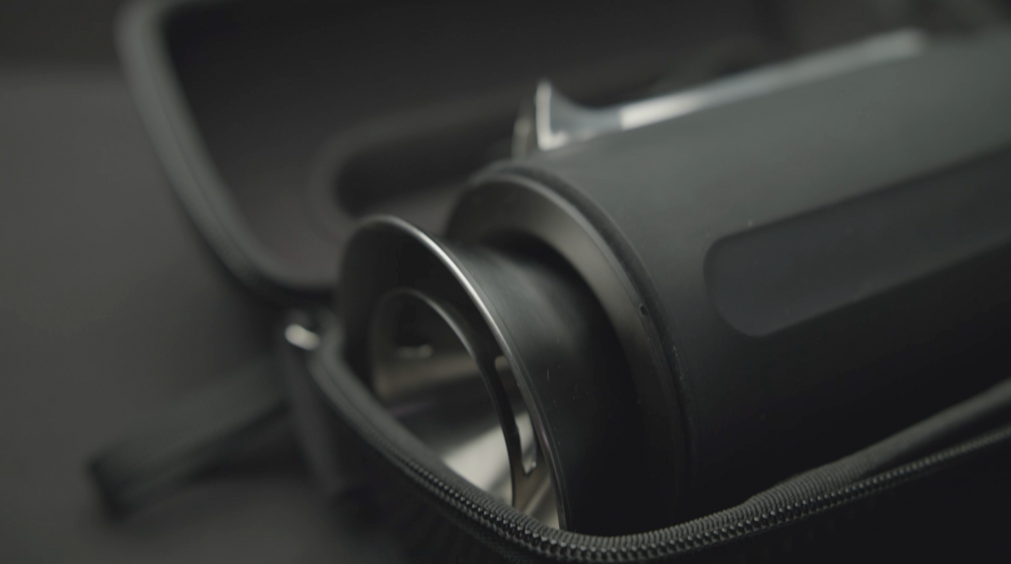 Close-up of a black cylindrical component of the Grandcart Coffee Kit inside a partially unzipped black carrying case.