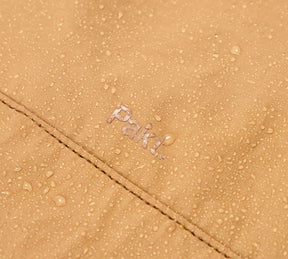 Close-up of the Mojave aeroweave fabric with water droplets and the word 'Pakt' embroidered.