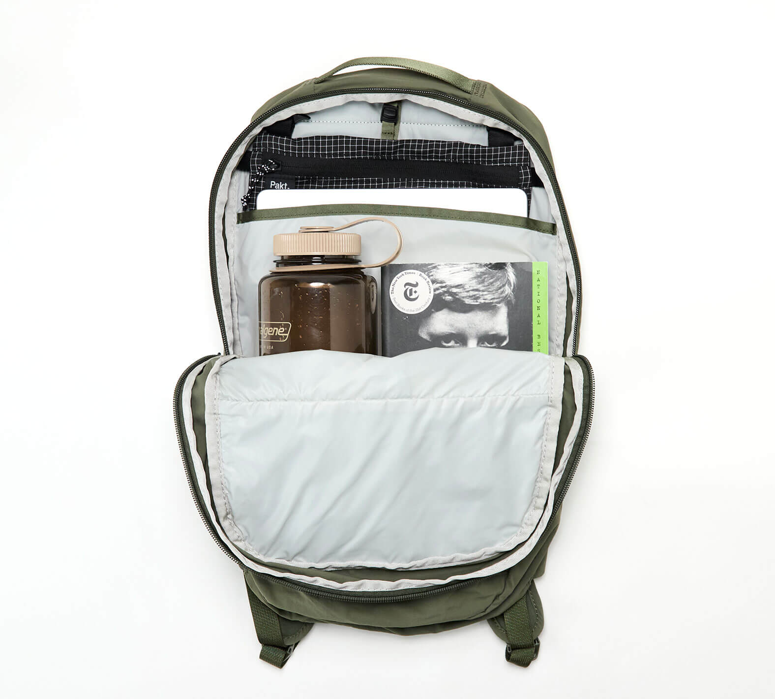 Open Stash Packable Backpack 16L showing interior with a water bottle and a book