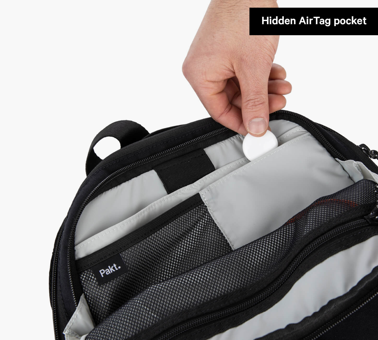 Hand placing a round AirTag into hidden pocket inside Everyday 22L Backpack; Grandcart. label visible; Hidden AirTag pocket.