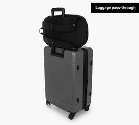 Black Everyday 22L Backpack attached to a gray rolling suitcase with luggage pass-through feature label visible