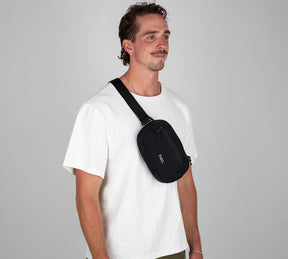 Black Grandcart. 3L sling bag worn crossbody on a male model's chest, white T-shirt