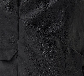 Close-up of black Aero Travel Backpack material with water droplets showing water resistance.