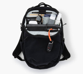 Open black Everyday 22L backpack showing organized interior pockets with water bottle, watch, sunglasses, and a key fob on orange cord