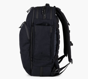 Side view of a black travel backpack with multiple compartments and padded shoulder straps.