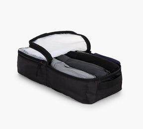 Black rectangular packing cube with open zippered lid and three rolled shirts inside