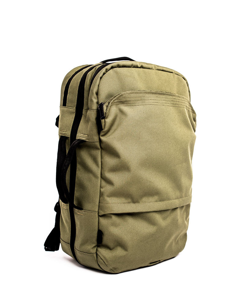 A faint green V1 Travel Backpack with multiple zippered compartments and black straps, shown against a white background.