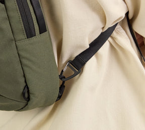 A close up shot of how the premium 15l shoulder strap attaches to the bag. It's being worn on a model.