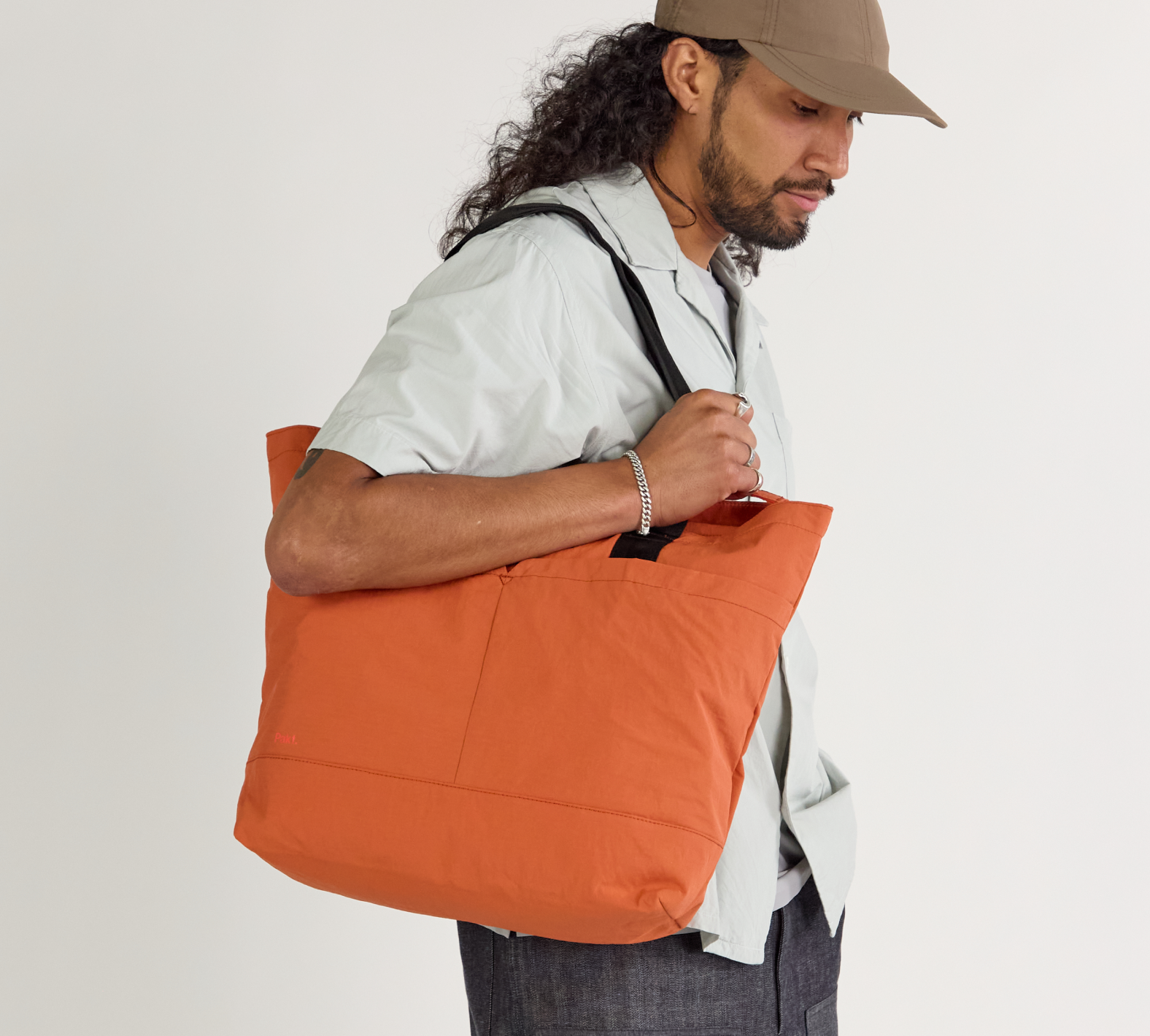 A model wearing the Stash tote in sumac.