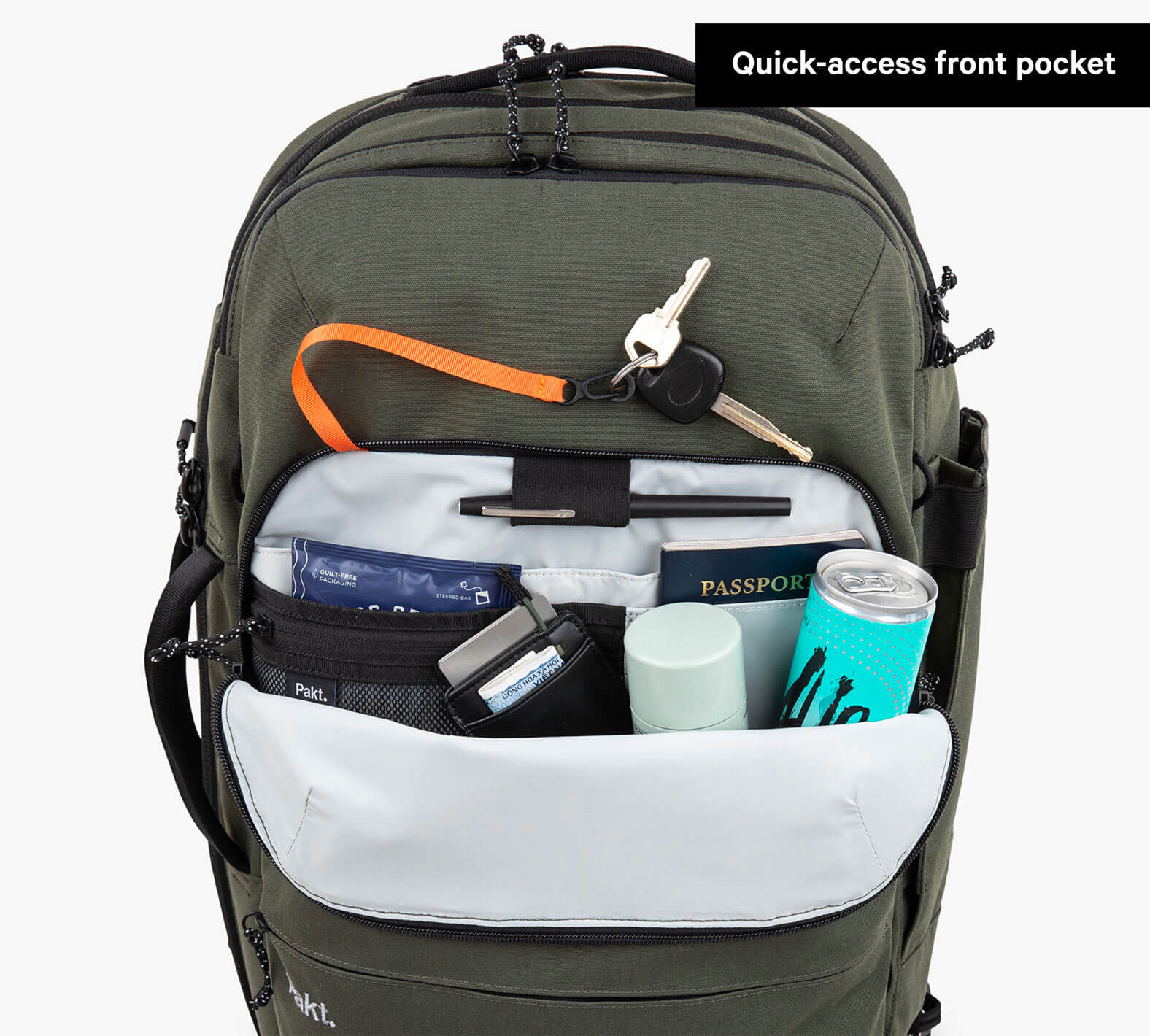 The Forest Travel Backpack with quick-access front pocket open, showing passport, keys, a can, and other travel items inside.
