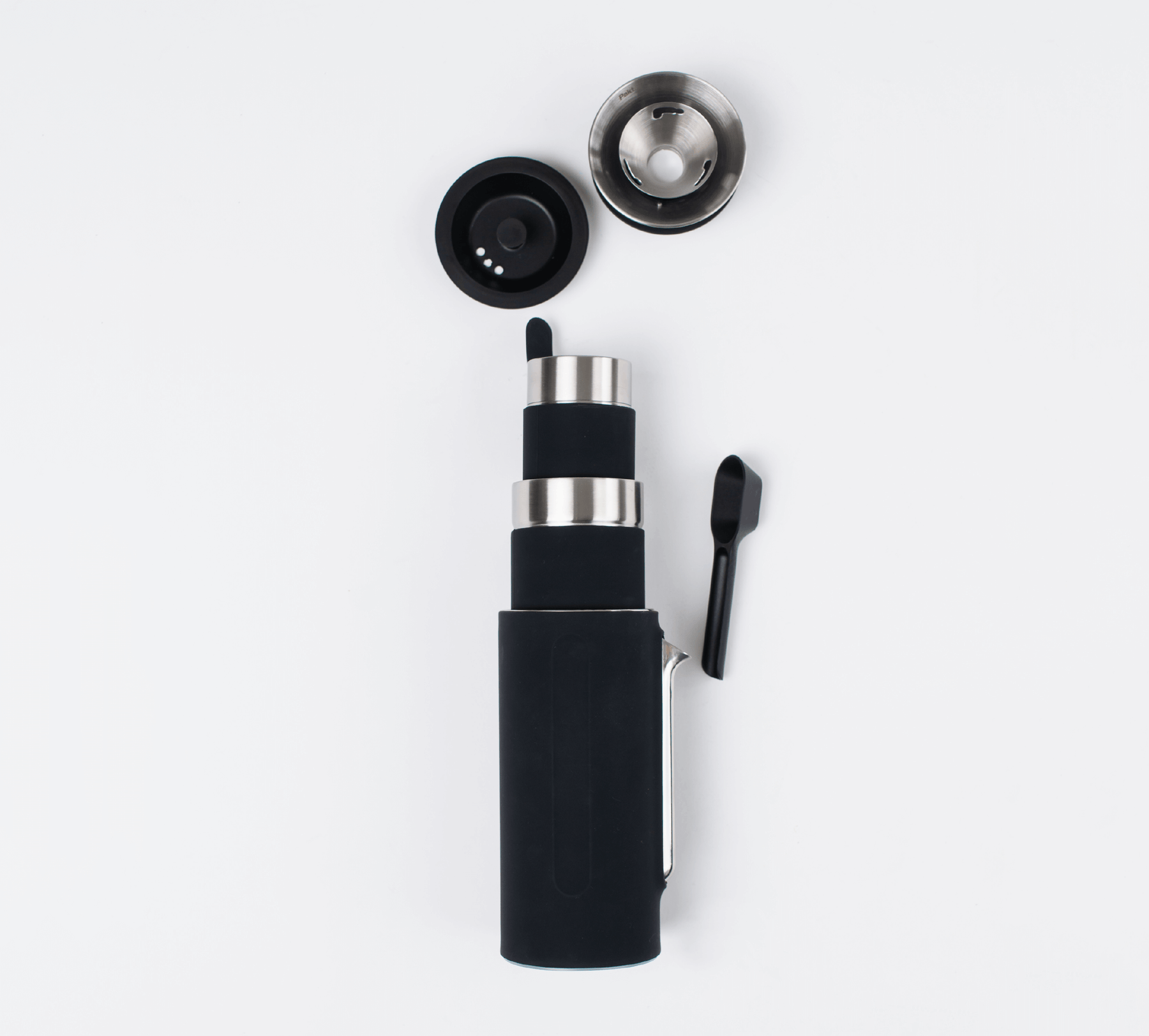 Black Grandcart Coffee Kit with a cylindrical main body, a detachable lid, a metal filter, and a small black scoop, all arranged on a white background.